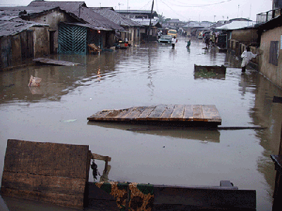 Its not the flood water, but rather washed up planks, appear to create a barrier         along this street at Agege, Lagos.