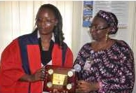 A graduating student from the programme in FUT Minna, Miss Sophie Agnes Kima (left), receiving an award from the Registrar of the university, Mrs Victoria Kolo