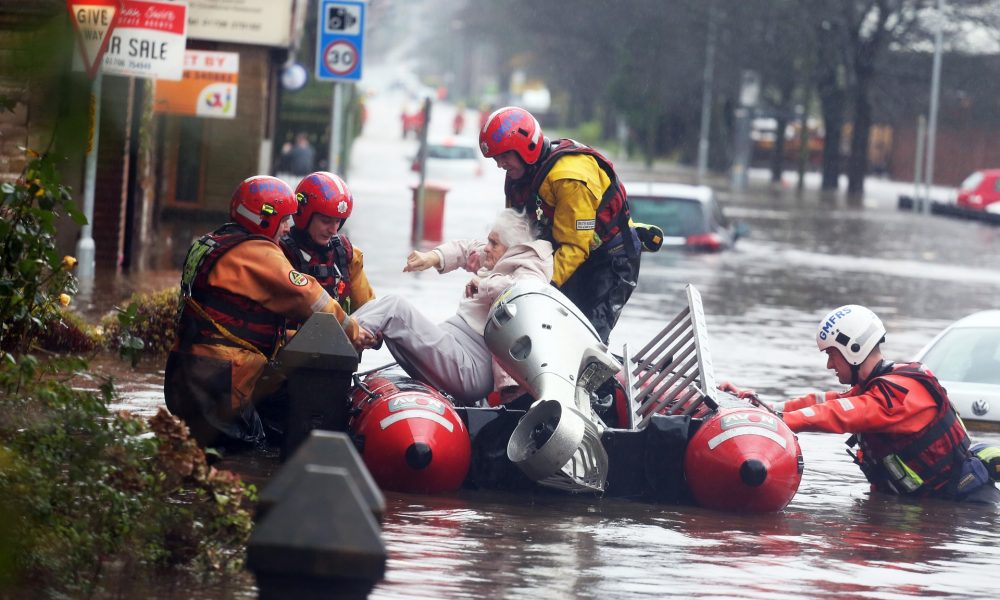 Fire and rescue services evacuate a woman from her flooded home in Littleborough, Greater Manchester. Photo credit: Demotix/Corbis
