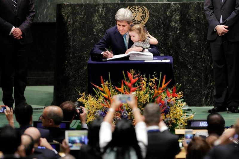 U.S. Secretary of State John Kerry holds his granddaughter Isabel Dobbs-Higginson as he signs the Paris Agreement on climate change, Friday, April 22, 2016