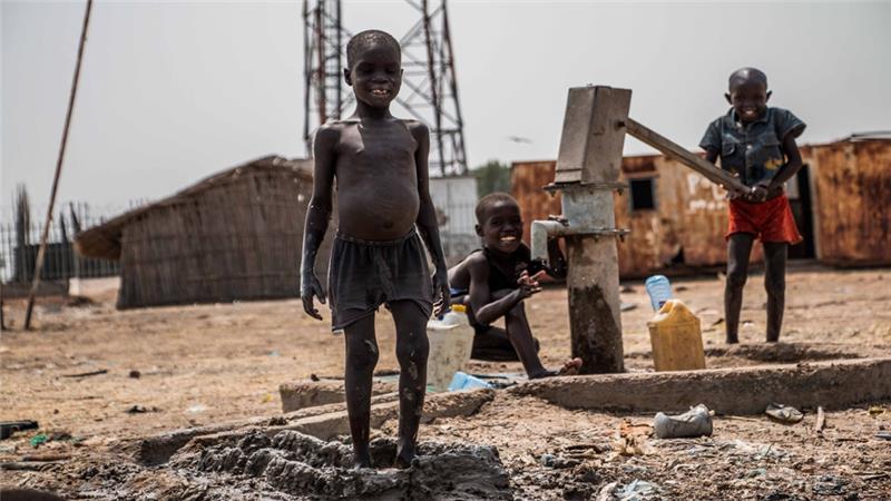 Children play at a water pump where the water is undrinkable because of contamination from a nearby oilfield in South Sudan