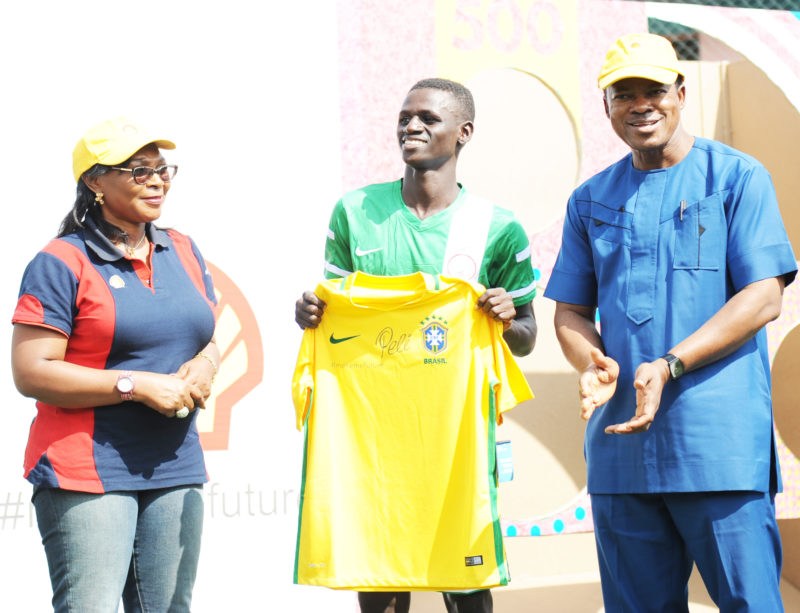L-R: General Manager, Portfolio Deepwater of The Shell Petroleum Development Company of Nigeria Limited, Mrs. Sophie Pokima; Football Captain of the Federal College of Education (Technical) Akoka, Lagos, Master Toyin Gbolahan; and the Provost of the College, Dr. Siji Olusanya, presenting a Pele-autographed Brazil Jersey to the captain after the Pele Power The Field Challenge in Lagos... on Thursday.