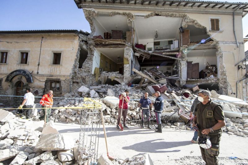 Rescuers stand by a collapsed house in Amatrice. More than 70 people were killed and hundreds injured as crews raced to dig out survivors. Photo credit: Massimo Percossi/ANSA via AP