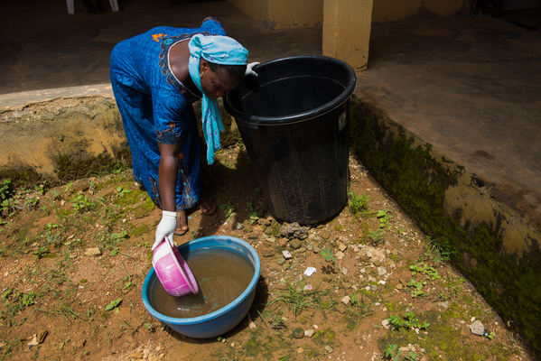 Gloria Samuel, 37, a cleaner at Bwari town Primary Health Centre, showing the rain water collected that is used to clean the toilets because there is no water supply to the centre. They also buy clean water to use for cleaning more sensitive sanitation and for patients who need clean water to wash. Upkuduru ward Bwari LGA, Abuja, Nigeria