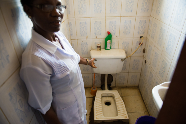 Martina Ohaegbulem, 56, the deputy nurse in charge/midwife showing the state of the toilets at the clinic. Zuba Primary Health Centre, Gwagwalada, Abuja, Nigeria.