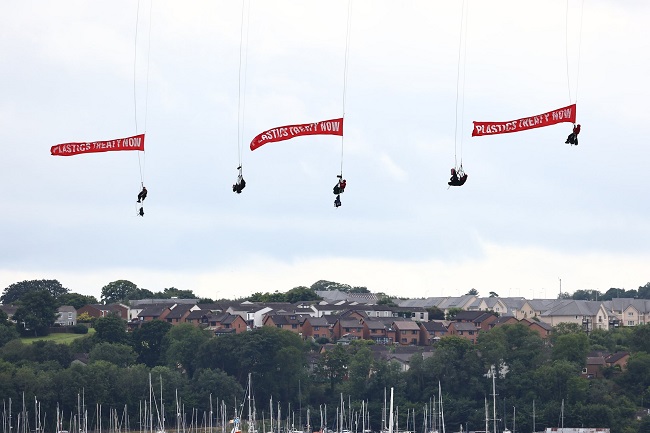 Plastic treaty: Greenpeace activists hang from suspended bridge to stop gas tanker